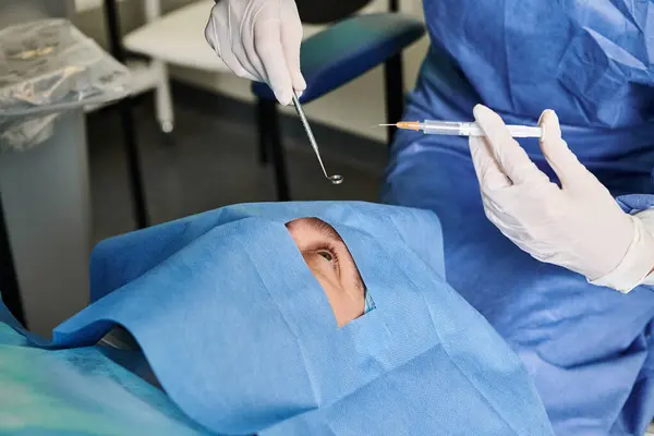 Um cirurgião em um vestido cirúrgico está realizando uma cirurgia em um paciente em um ambiente médico. — Fotografia de Stock