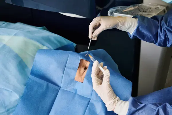 Cirujano en bata de hospital realizando cirugía a un paciente. - foto de stock