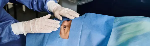 Person im blauen Anzug und weißen Handschuhen in einer Arztpraxis zur Laser-Sehkorrektur. — Stockfoto