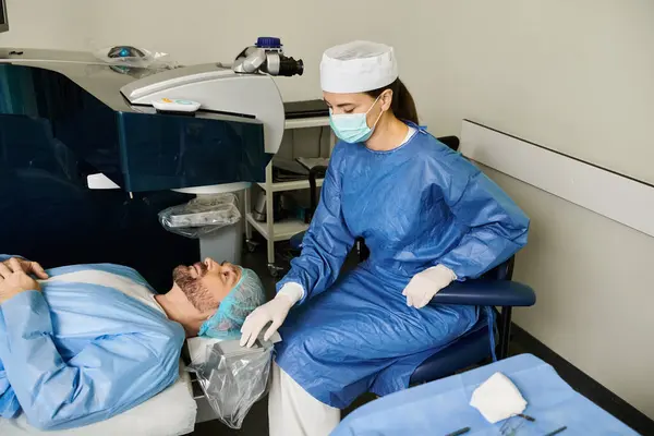 Mujer y hombre en batas azules esperan corrección de visión láser en el hospital. - foto de stock