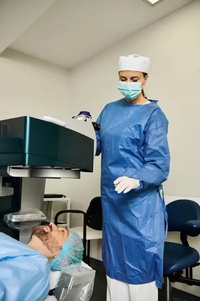 Una mujer con una bata quirúrgica está en una habitación en el consultorio de un médico. - foto de stock