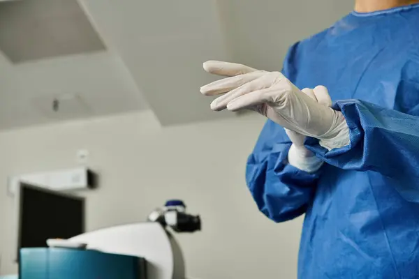 Une femme en robe bleue et des gants blancs dans une clinique de correction de la vue au laser. — Photo de stock