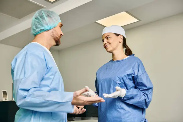 Um homem e uma mulher em esfoliação discutindo em um ambiente médico. — Fotografia de Stock