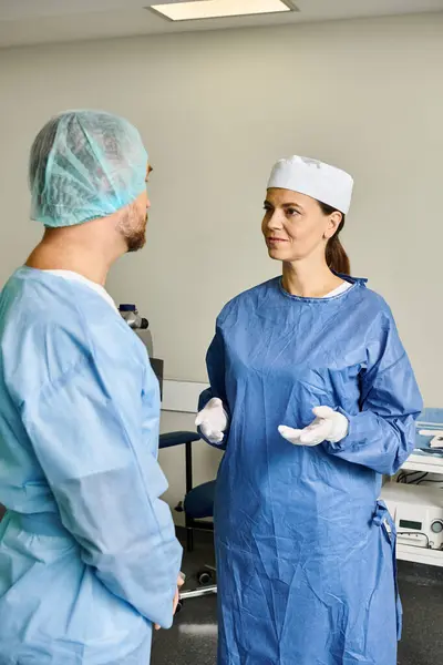 A man and woman in scrubs discussing laser vision correction. - foto de stock