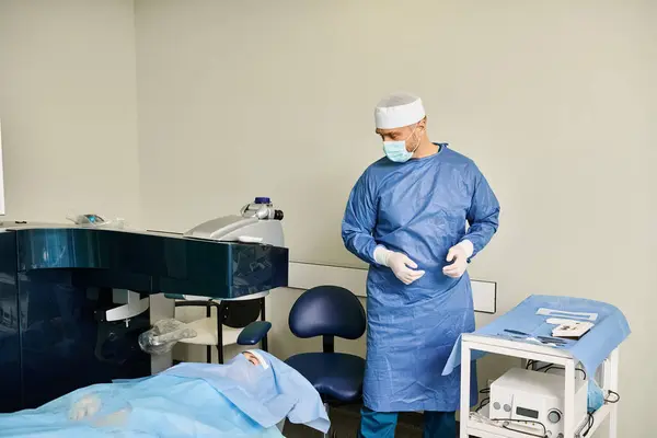 Um homem com um vestido cirúrgico fica ao lado de uma cama em um ambiente médico. — Fotografia de Stock