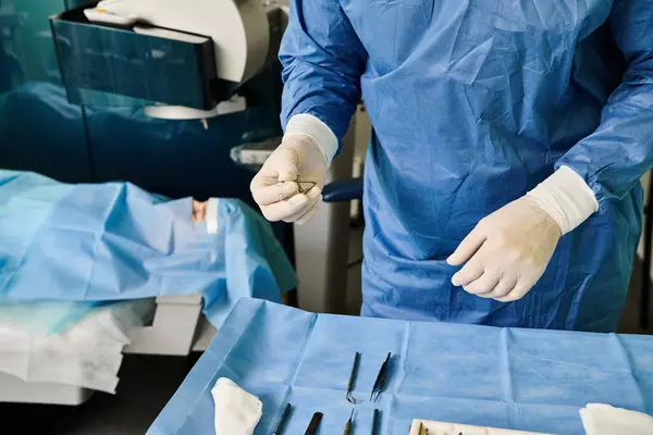 Un hombre con una bata de hospital y guantes preparándose para la corrección de la visión láser. - foto de stock