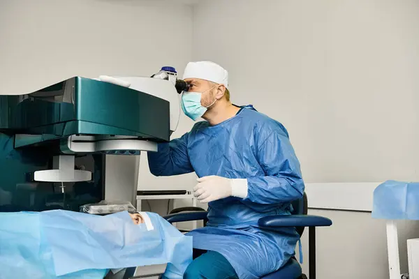 Un hombre con bata quirúrgica opera una máquina médica. - foto de stock