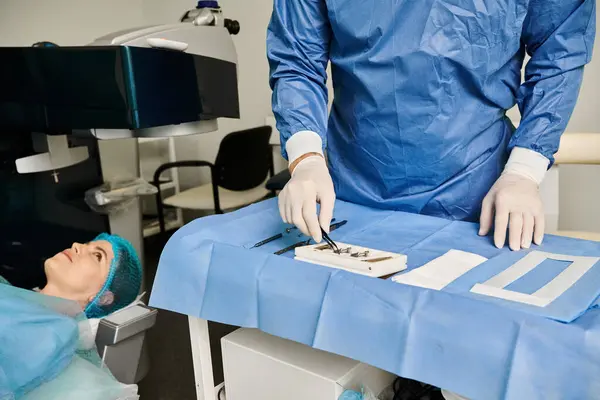 Uma pessoa em um vestido cirúrgico opera uma máquina em um ambiente médico. — Fotografia de Stock