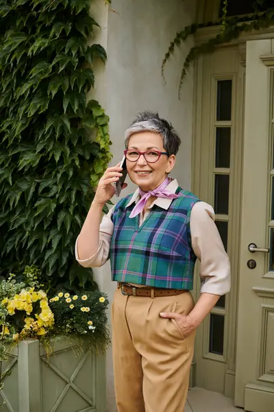 Boa aparência mulher alegre sofisticada em traje chique falando por telefone e sorrindo para a câmera — Fotografia de Stock