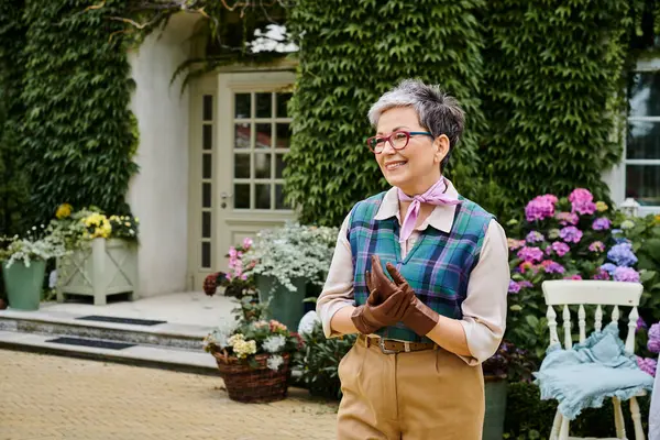Сложная зрелая веселая женщина в элегантной одежде позирует возле своего дома в Англии и смотрит в сторону — стоковое фото