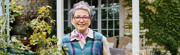 Sophisticated mature jolly woman with short hair smiling at camera near her house in England, banner — Stock Photo