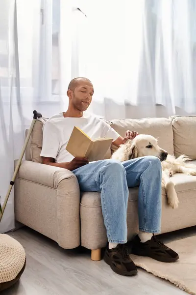 Африканський американець з міастенією гравієм сидить на дивані зі своїм собакою Лабрадором, демонструючи різноманітність і включення. — стокове фото