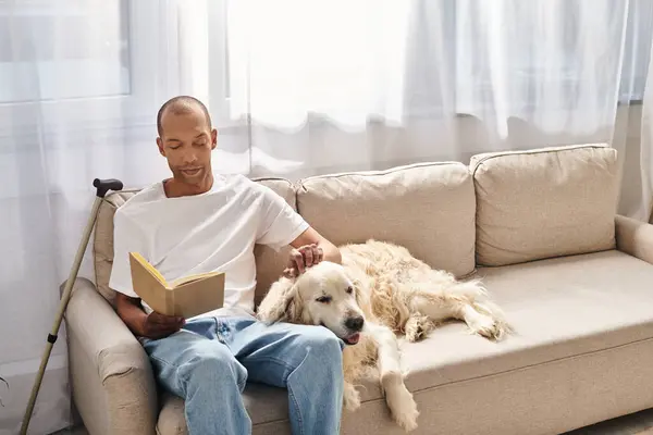 Un Afro-Américain atteint de myasthénie se détend sur un canapé avec son fidèle chien du Labrador, incarnant diversité et inclusion. — Photo de stock