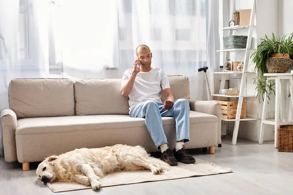 An African American man with myasthenia gravis sits on a couch, accompanied by his loyal Labrador dog in a cozy setting. — Stock Photo