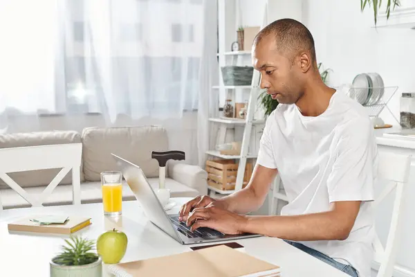 Um homem afro-americano deficiente com Miastenia Gravis criando, trabalhando e se conectando com o mundo usando um laptop. — Fotografia de Stock