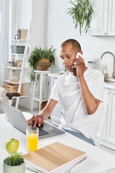 Homem afro-americano com deficiência com miastenia gravis usando um laptop em uma mesa de cozinha. — Fotografia de Stock