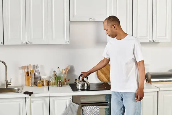 Un afroamericano discapacitado con síndrome de miastenia grave se encuentra en una cocina cerca de la estufa - foto de stock