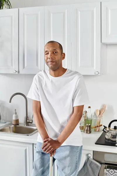Ein afroamerikanischer Mann mit Myasthenia-gravis-Syndrom steht selbstbewusst in einer Küche — Stockfoto