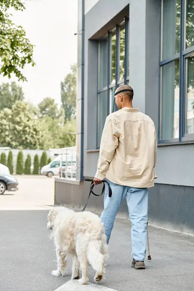 Инвалид афроамериканец с синдромом миастении грависа выгуливает белого пса-лабрадора по улице, демонстрируя разнообразие и включенность.. — стоковое фото