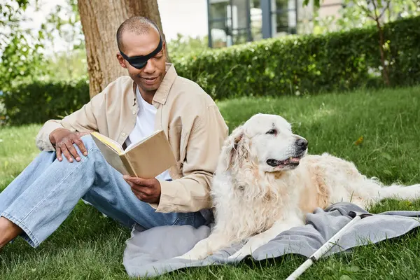 Человек с синдромом миастении и грависом читает книгу со своей верной собакой-лабрадором рядом в безмятежной травянистой обстановке.. — стоковое фото