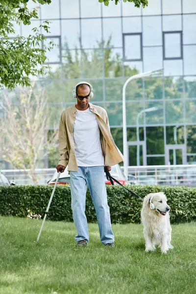 An African American man with myasthenia gravis walking a white Labrador dog on a leash in a show of diversity and inclusion. — Stock Photo