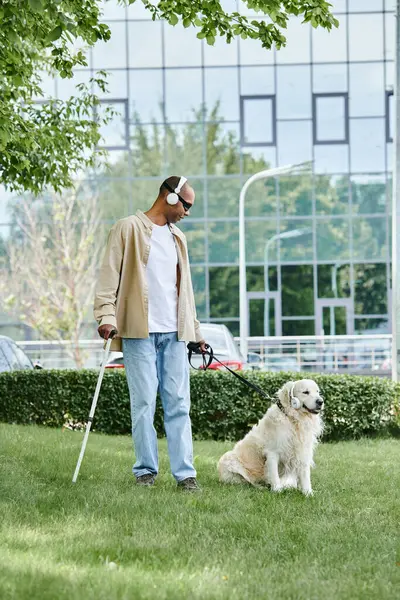 An African American man with myasthenia gravis syndrome walks a Labrador dog, promoting diversity and inclusion. — Stock Photo