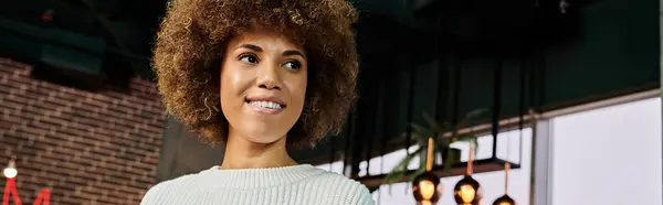 Un primer plano de una mujer afroamericana sonriendo en un café moderno. - foto de stock