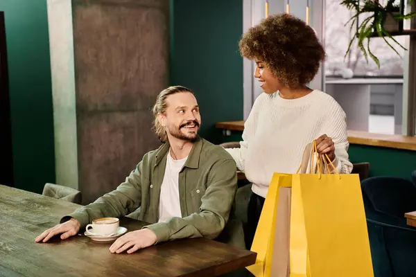 Uma mulher afro-americana e um homem pacificamente sentados juntos em uma mesa de café moderna, envolvidos em conversa e conexão. — Fotografia de Stock