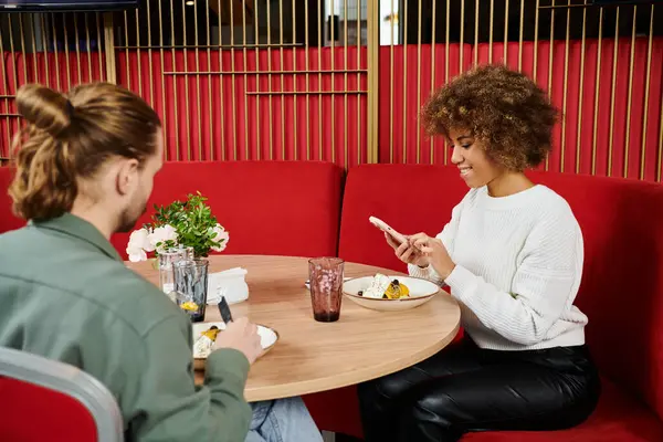 Пара різноманітних фонів займаються глибокою розмовою за затишним столом для кафе, оточеним спокійною атмосферою. — стокове фото