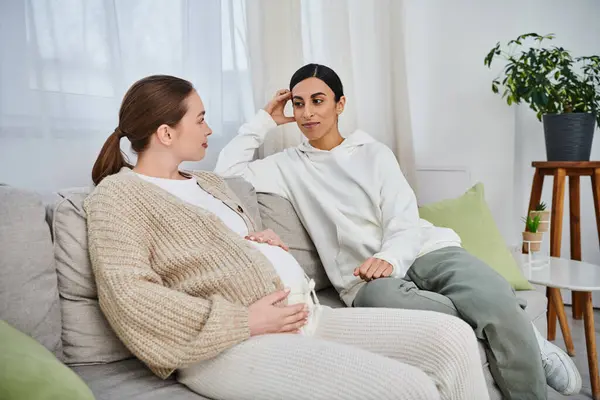 Una donna incinta e il suo allenatore siedono insieme su un accogliente divano durante i corsi dei genitori, costruendo un forte legame.. — Foto stock