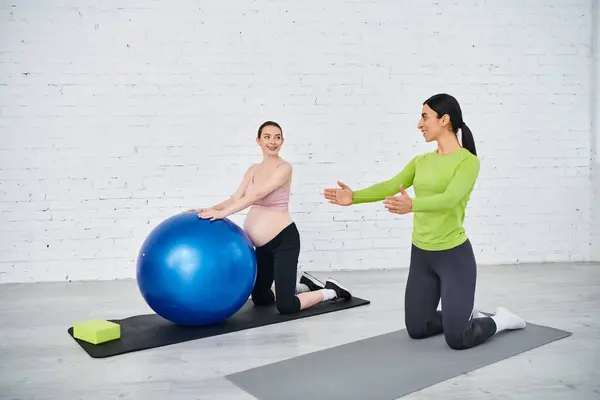 Deux femmes, dont une enceinte, font des exercices sur des balles d'exercice sous la direction d'un entraîneur pendant les cours pour parents. — Photo de stock