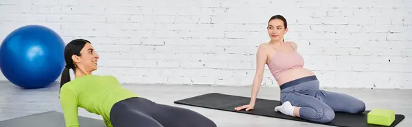 Dos mujeres, una embarazada, realizan con gracia posturas de yoga en un entorno sereno, guiadas por un instructor durante un curso de padres. - foto de stock