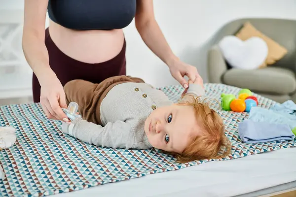 Ein Baby liegt friedlich neben einer jungen Frau auf einem Bett und fängt einen ruhigen und nährenden Moment zwischen Mutter und Kind ein. — Stockfoto
