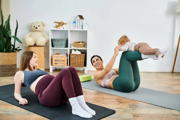 Eine junge Mutter praktiziert anmutig Yoga mit ihrem Baby, angeleitet von einem Lehrer in einem gemütlichen Ambiente zu Hause während der Elternkurse. — Stockfoto