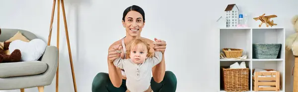 Uma jovem e bela mãe embala seu bebê em seus braços, recebendo orientação de seu treinador em um curso para pais. — Fotografia de Stock