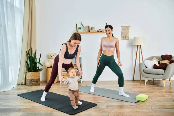 Una madre joven y hermosa practica yoga junto a su bebé con la guía de un entrenador en un curso de padres. - foto de stock