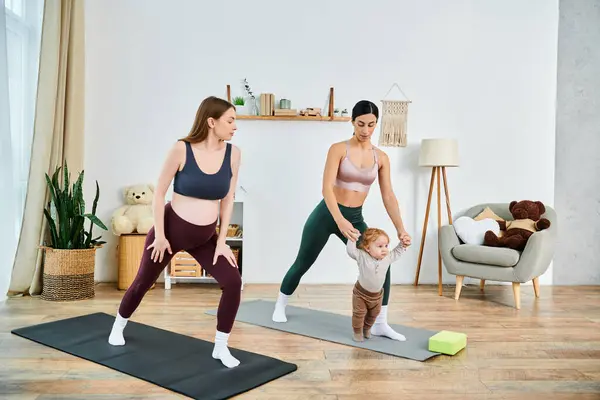 Una joven madre y su bebé practican yoga en su acogedora sala de estar bajo la guía de su instructor. - foto de stock