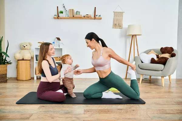 Una madre y dos niños practican yoga en su acogedora sala de estar mientras un entrenador los guía a través de diferentes poses.. - foto de stock