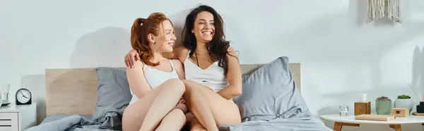 Aimant couple lesbien en tenue élégante assis ensemble sur le lit. — Photo de stock