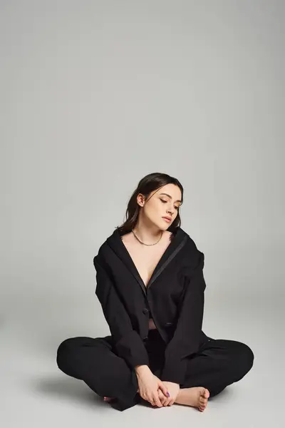 Eine schöne Plus-Size-Frau in stylischer Kleidung sitzt mit geschlossenen Augen auf dem Boden und strahlt Ruhe und Introspektion aus. — Stockfoto