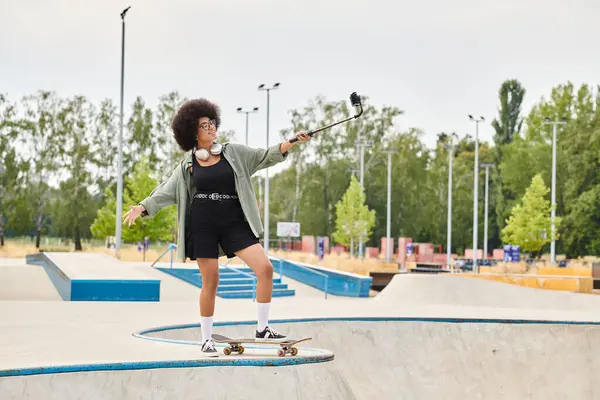Eine junge Afroamerikanerin mit lockigem Haar fährt gekonnt auf einem Skateboard in einem belebten Skatepark. — Stockfoto
