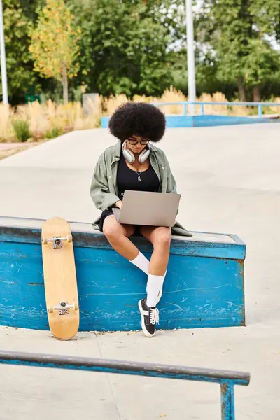 A young person sitting on a bench with a laptop, working or studying outdoors. — Stock Photo