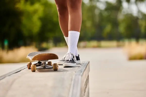 A young African American woman rides a skateboard on a ramp in a skate park, showcasing her skills. — Stock Photo