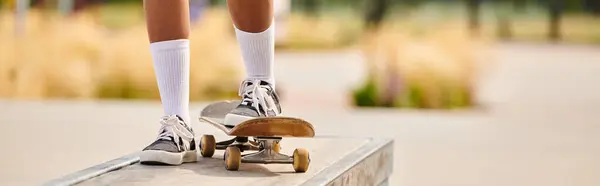 A young African American woman confidently rides a skateboard on a ramp at a skate park. — Stock Photo