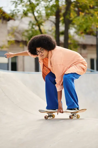 Curly-haired African American woman skateboarding on outdoor ramp in skate park with skill and style. — Stock Photo
