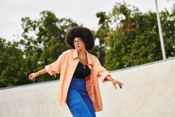 A determined young African American woman with curly hair riding a skateboard up the side of a ramp at an outdoor skate park. — Stock Photo