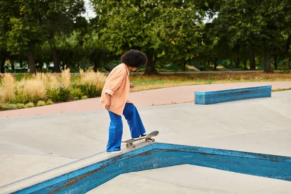 Jovem afro-americana confiantemente monta seu skate em uma rampa com habilidade e determinação. — Fotografia de Stock
