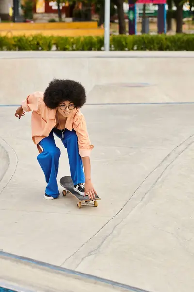 Eine junge Afroamerikanerin mit lockigem Haar skateboardet auf einer Rampe in einem Outdoor-Skatepark und zeigt beeindruckende Fähigkeiten. — Stockfoto