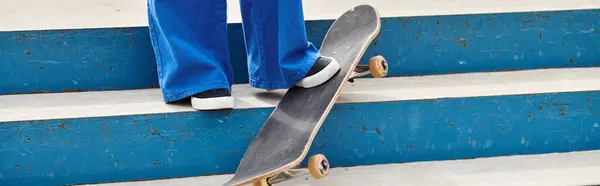 Una joven afroamericana se para en un escalón, patinando con confianza en un vibrante parque de skate al aire libre. - foto de stock