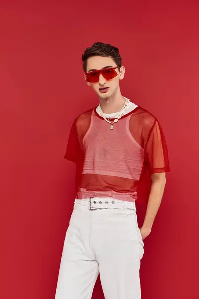 Fashionable modish androgynous man with red stylish fishnet and sunglasses looking at camera — Stock Photo